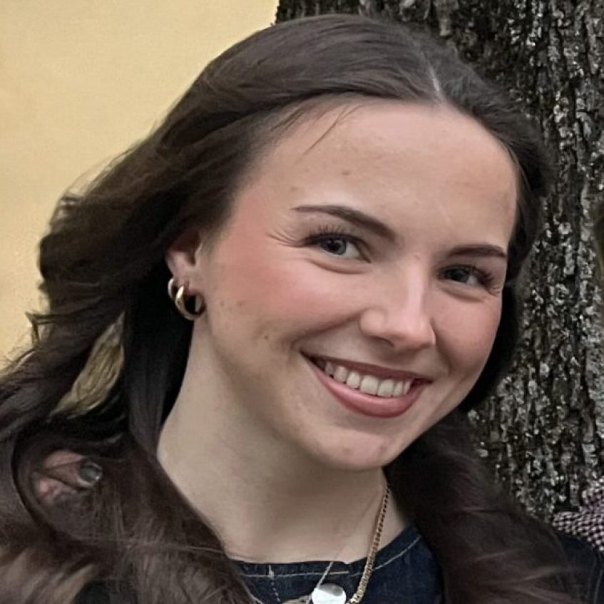 Mörkhörig ung kvinna som leer.